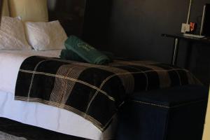 a bed with a blanket and a chair in a room at Beulah group House in Roodepoort +9 photos