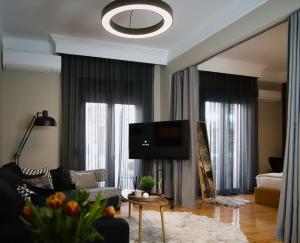 a living room with a couch and a flat screen tv at 4 TRAVELERS Together in Thessaloniki
