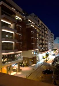 a night view of a large building with a parking lot at 4 TRAVELERS Together in Thessaloniki