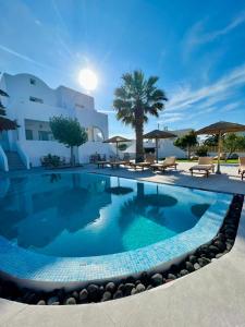 a large swimming pool in front of a building at Santorini Villatzio Suites in Mesaria