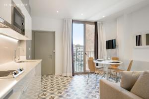 een keuken en een woonkamer met een tafel en een eetkamer bij Uma Suites Sagrada Familia in Barcelona