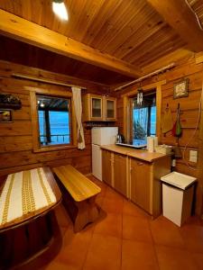 a kitchen with a bench and a table in a cabin at Country side/Kaštonų alėja - Sodyba in Sudeikiai