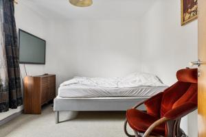 a bedroom with a bed and a chair and a tv at Tysso Apartment in Tveit