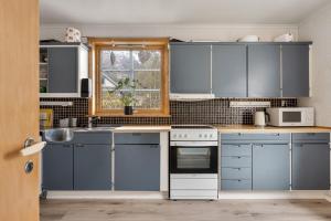 a kitchen with blue cabinets and a window at Tysso Apartment in Tveit