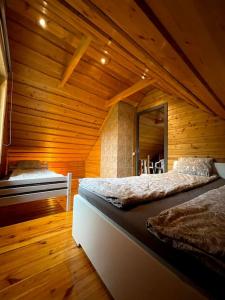 a bedroom with two beds in a wooden room at Country side/Kaštonų alėja - Sodyba in Sudeikiai