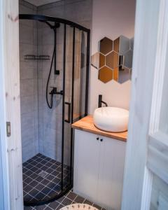 uma casa de banho com um chuveiro e um lavatório. em Cozy apartment in the city center of Kärdla em Kärdla