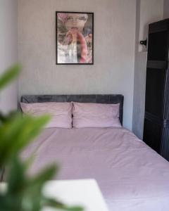 a bed in a bedroom with a picture on the wall at Cozy apartment in the city center of Kärdla in Kärdla