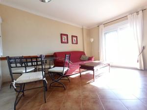 salon z czerwoną kanapą i krzesłami w obiekcie Pleno centro de Isla Canela, primera linea de playa w mieście Isla Canela +3 zdjęcia