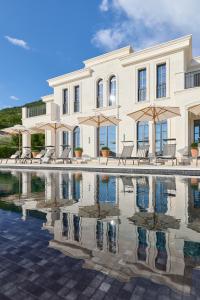 a large house with a pool in front of it at Eterno Villas in Budva