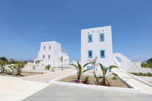 un bâtiment blanc avec des palmiers devant lui dans l'établissement Xenos Villa 5 with a Private pool near the sea, à Tigaki