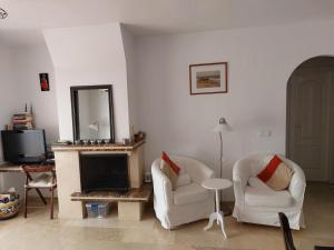 uma sala de estar com duas cadeiras e uma lareira em Azahar em Alicante