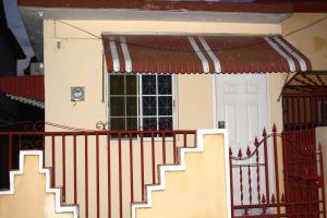 una pequeña casa con una puerta y una ventana en Cozy Oasis Studio, en Portmore