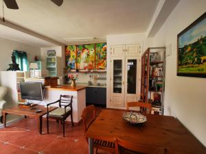 a kitchen and dining room with a table and a desk at Casa Luz in Málaga