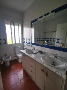 a bathroom with two sinks and a toilet and a mirror at Casa Luz in Málaga