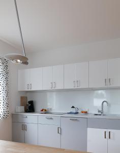 uma cozinha branca com armários brancos e um lavatório em Spacious, quiet 4 room flat em Salzburgo