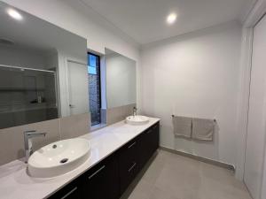 a white bathroom with two sinks and a mirror at Sun and Sea Holiday Home in Cowes