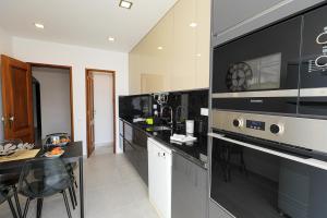 cocina con encimeras negras y microondas en Parkway Entrance Apartment in Lagos, en Lagos