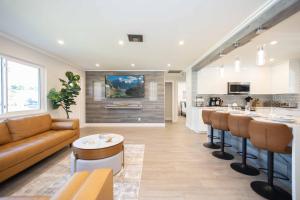 eine Küche und ein Wohnzimmer mit einer Couch und einer Bar in der Unterkunft Fantasy Resort OMG PoolWaterfall outdoorKitchn Gym in Lake Worth