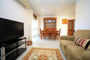 Una sala de estar con un sofá y un televisor de pantalla plana. en Parkway Entrance Apartment in Lagos, en Lagos