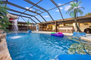 - une piscine avec une fontaine dans une maison dans l'établissement Fantasy Resort OMG PoolWaterfall outdoorKitchn Gym, à Lake Worth