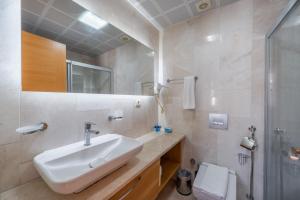 a white bathroom with a sink and a shower at Majeste Hotel Bodrum in Bodrum City