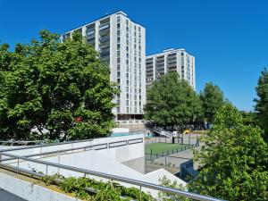 a view of two tall buildings in a park at Studio with balcony and a great sea view in Helsinki