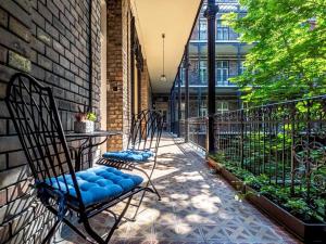 dos sillas sentadas en un porche con una valla en Westend Apartment, en Budapest