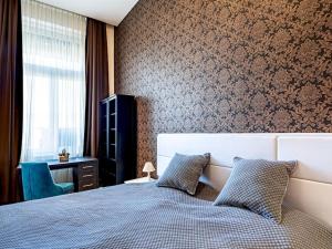 a bedroom with a bed and a chair and a window at Westend Apartment in Budapest