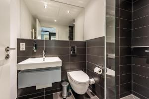 a bathroom with a toilet and a sink and a mirror at Premier Inn München City Schwabing in Munich