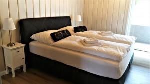 sypialnia z 2 łóżkami z białą pościelą i czarnym zagłówkiem w obiekcie Nordsee Urlaubsparadies w mieście Butjadingen