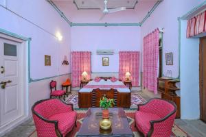 a bedroom with a bed and a table and chairs at Neemrana's - Piramal Haveli in Bagar +35 photos