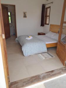 1 dormitorio con 1 cama y suelo de baldosa en la maison de la fontaine en Cap Skirring