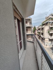 uma varanda com vista para um edifício em Cozy flat em Atenas