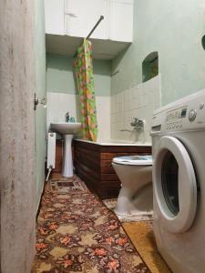 uma casa de banho com um WC e uma máquina de lavar roupa em Authentic apartment in the centre em Chisinau