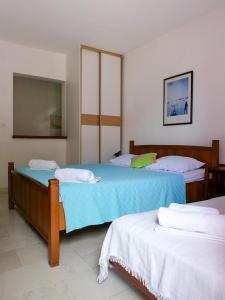 a bedroom with two beds and a mirror at Apartments Almaja Villa in Petrovac na Moru