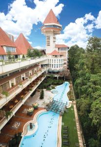 eine Luftansicht eines Resorts mit Pool und Turm in der Unterkunft Golf Course Hotel in Kampala