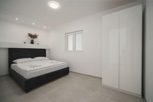 una camera bianca con un letto con testiera nera di Rooftop House Vodice a Vodice Altre 70 foto