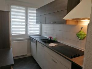 a kitchen with white cabinets and a black counter top at Ferienwohnung August 24 in Gelenau