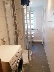 a bathroom with a shower and a washing machine at Ferienwohnung August 24 in Gelenau