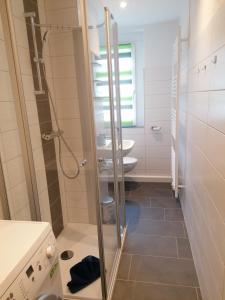 La petite salle de bains est pourvue d'une douche et d'un lavabo. dans l'établissement Ferienwohnung August 24, à Gelenau