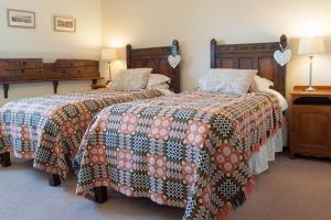 two beds in a hotel room with two beds sidx sidx sidx at Bach y Graig cottage in St Asaph