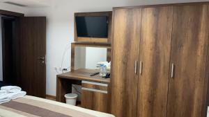 a bedroom with a wooden cabinet with a television on it at Bici Resort in Dobrosin
