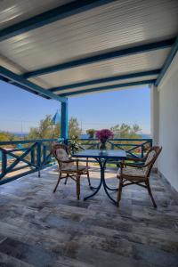 a table with two chairs and a vase of flowers on a balcony at Club Afrodit Tatil Köyü in Altınoluk