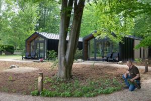 a man sitting on the ground in front of a house at Herberg Restaurant 't Zwaantje in Mook