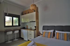 a bedroom with a bed and a desk and a kitchen at Antigonis Garden House in Chania