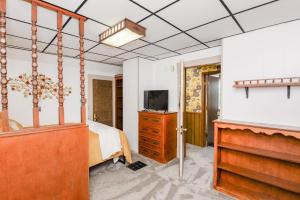 1 dormitorio con cama y vestidor con TV en Unique Two Story with a Vintage Flare en Fargo