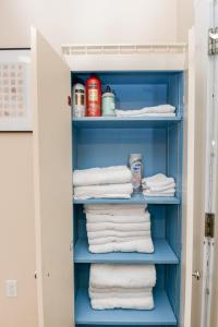 um armário com prateleiras azuis e toalhas brancas em Unique Two Story with a Vintage Flare em Fargo