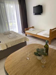 a room with two beds and a table with wine glasses at Vila Dvorski in Baška Voda