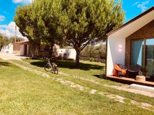 een huis met een fiets geparkeerd naast een boom bij Casinhas da Póvoa- Turismo Natureza in Castelo de Vide