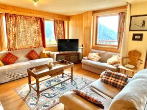 a living room with a couch and a tv at Luxury Chalet Liosa - Ski in Ski out - Amazing view in Corvara in Badia